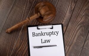 Bankruptcy law text on the paper with gavel on wooden background 