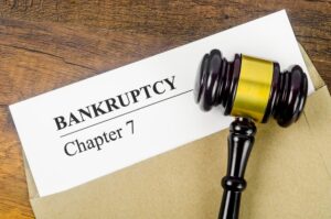 Bankcrupty Chapter 7 text on Document form and Wooden Gavel on office desk.
